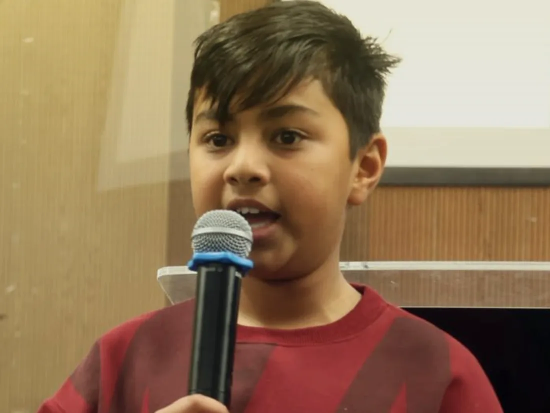 A young boy speaking to the congregation