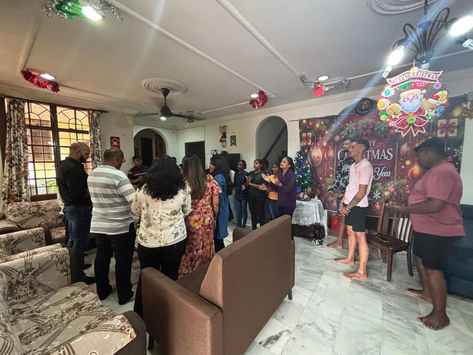 A gathering standing in prayer together at Christmas