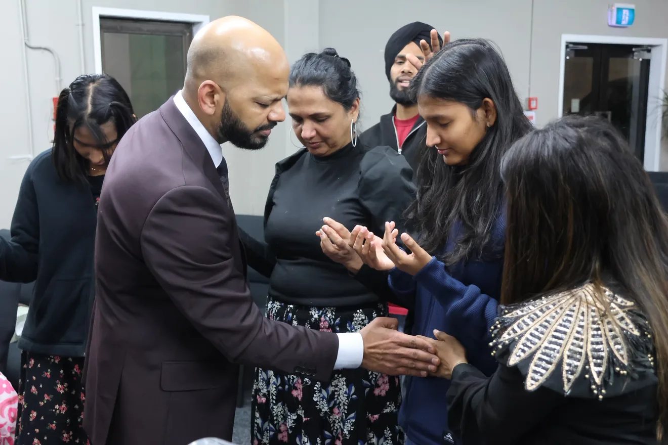 Members of the congregation praying together with open hands
