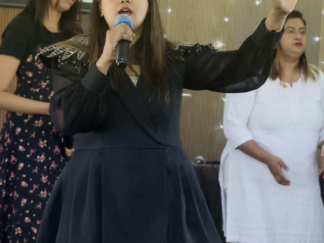 Leading the congregation in worship with arms outstretched