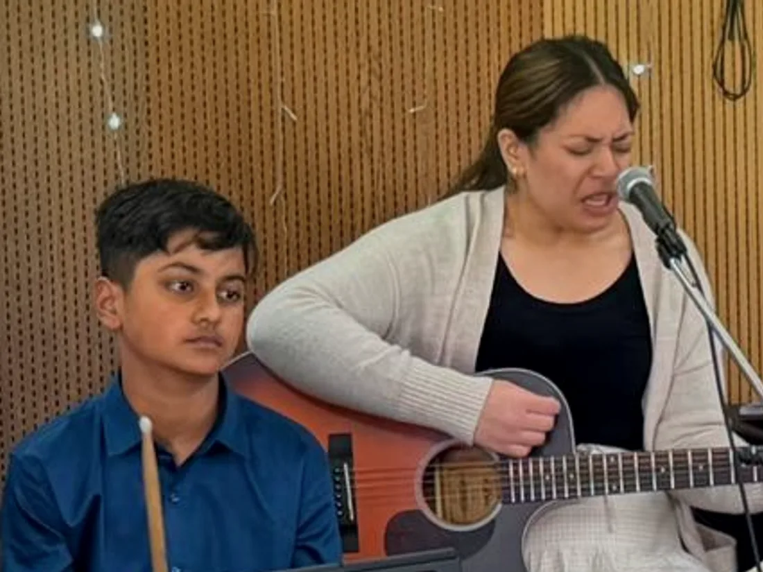 A young member of the church playing guitar during worship